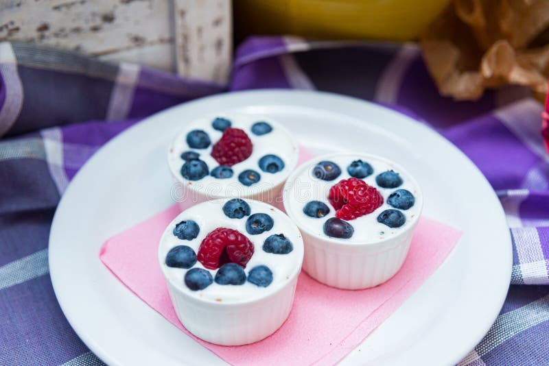 Three Servings of Yogurt Dessert with Fresh Raspberries and Blueberries