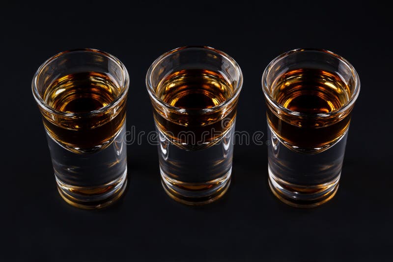 Three shots with cognac or jager on black