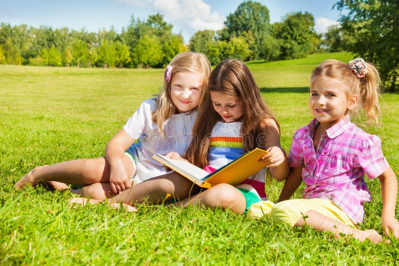 Three sisters read book in the park