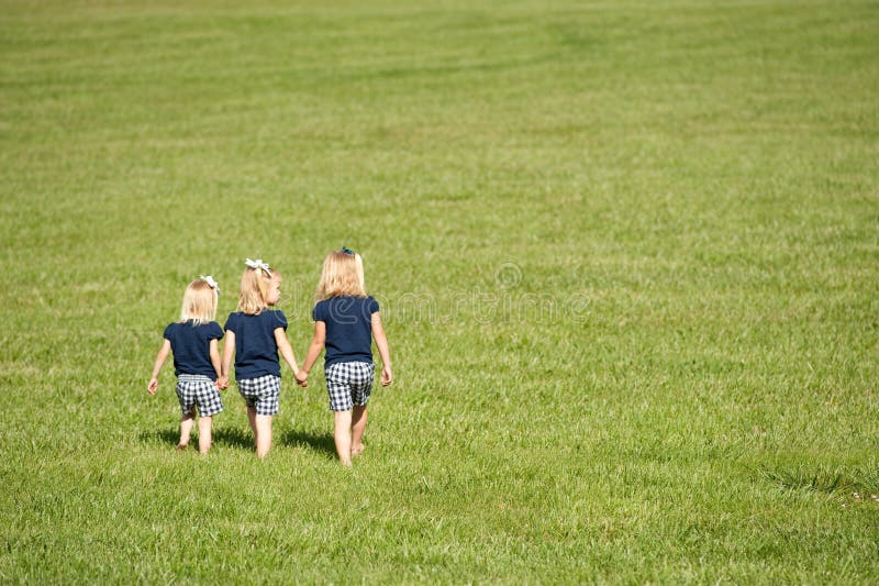 Three sisters walking in a field