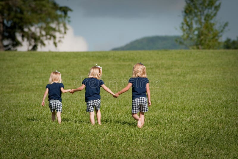 Three sisters walking in a field