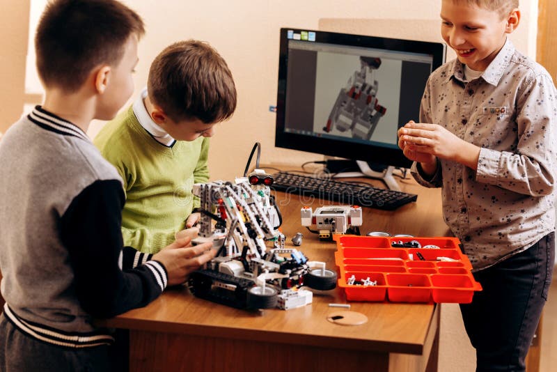 Three smart boys are making robots from the robotic constructor in the School of Robotics royalty free stock photo Three smart boys are making robots from the robotic constructor in the School of Robotics royalty free stock photo