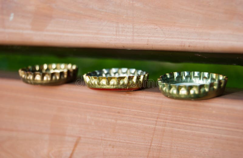3 Beer Bottle Caps on a Bench Stock Photo Image of horizontal, smile