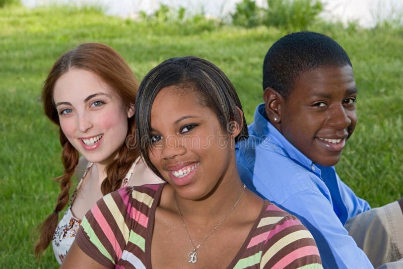 Three Teenage Friends Sitting in the Grass