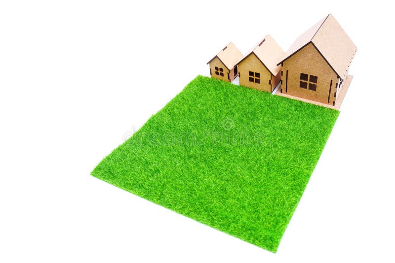 Three toy houses with a fake grass in front royalty free stock photo