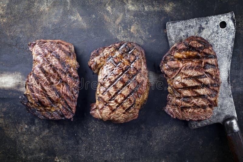 Three Traditional Barbecue Entrecote Beef Steaks with Rustic Kitchen