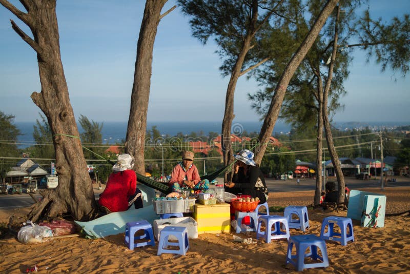 Three Vendors Sitting On A Sand Dune. Three street vendors sit on a sand dune in Mui Ne, Vietnam. The woman in an orange shirt and flowery pant sit on a hammock royalty free stock photography Three Vendors Sitting On A Sand Dune. Three street vendors sit on a sand dune in Mui Ne, Vietnam. The woman in an orange shirt and flowery pant sit on a hammock royalty free stock photography
