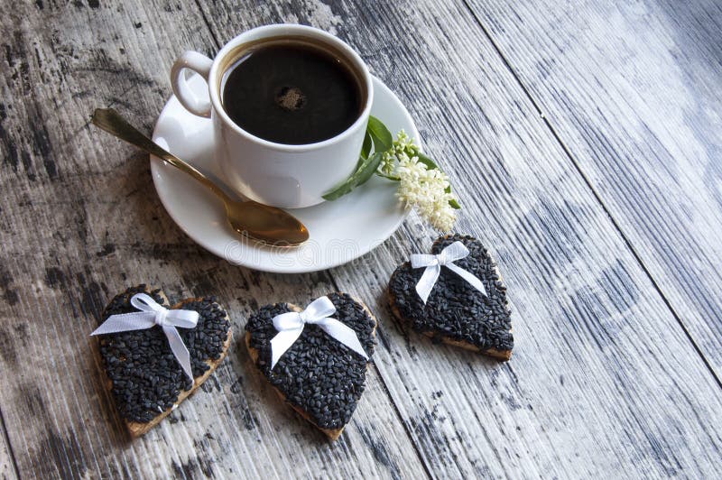 Three wedding cookies decorated black sesame with a cup of coffee. Retro style.