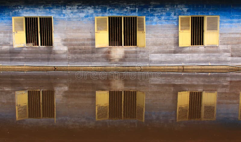 Tres ventanas de de madera cabana refleja en un rio agua, en,,.