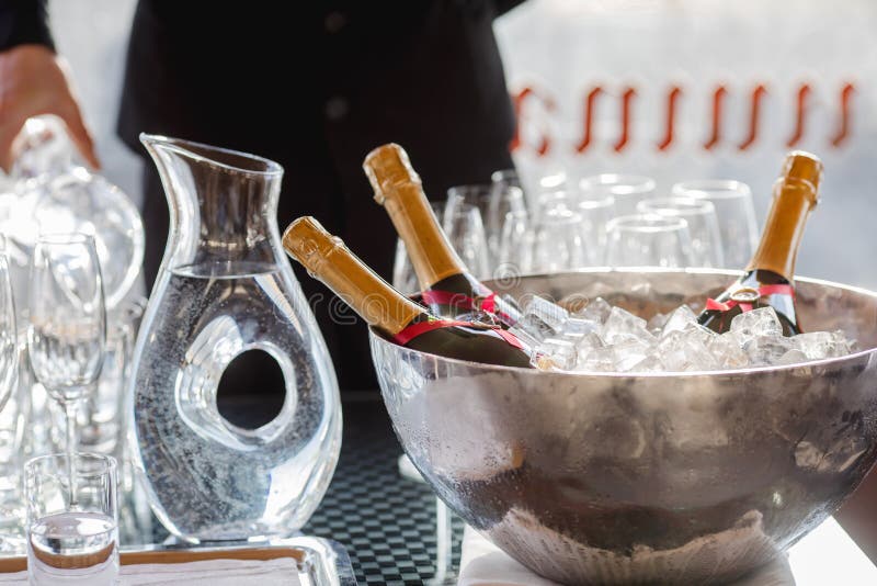 Three wine bottles chill in ice bucket