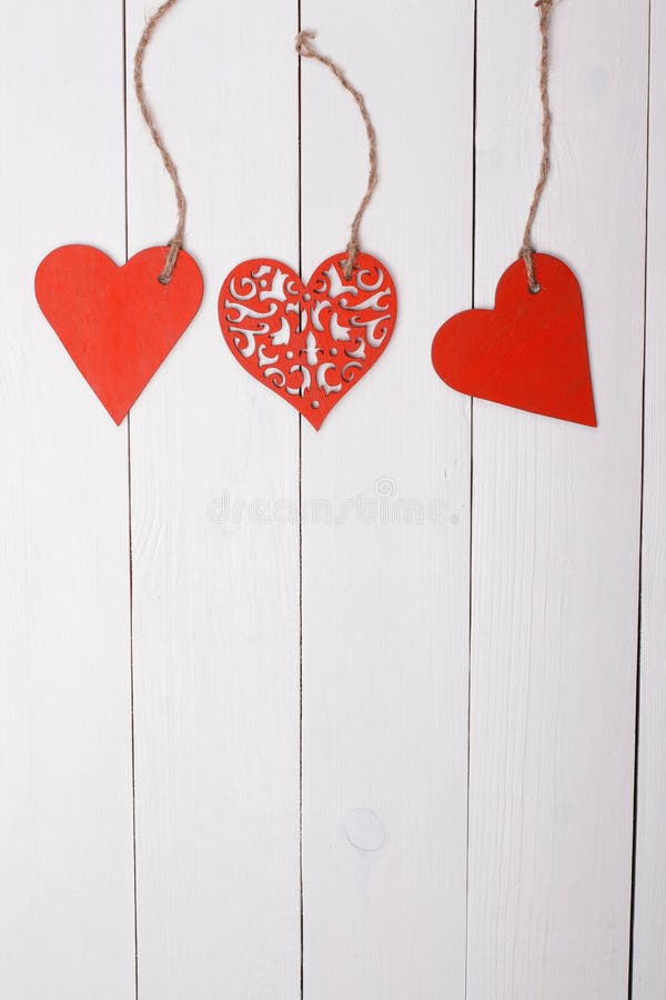 Three wood hearts on a wooden table