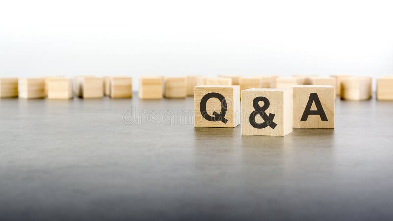 Three wooden blocks with letters Q and A with focus to the single cube in the foreground in a conceptual image on grey stock image