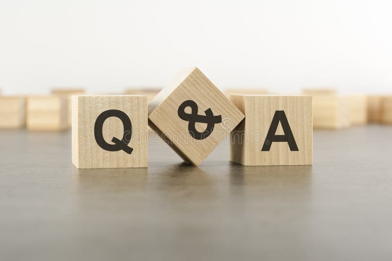 Three wooden blocks with letters Q and A with focus to the single cube in the foreground in a conceptual image on grey stock photo
