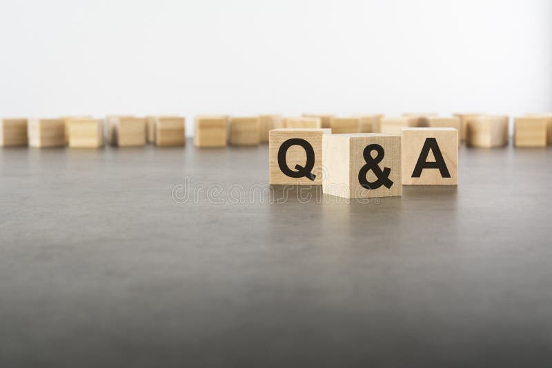 Three wooden blocks with letters Q and A with focus to the single cube in the foreground in a conceptual image on grey stock image