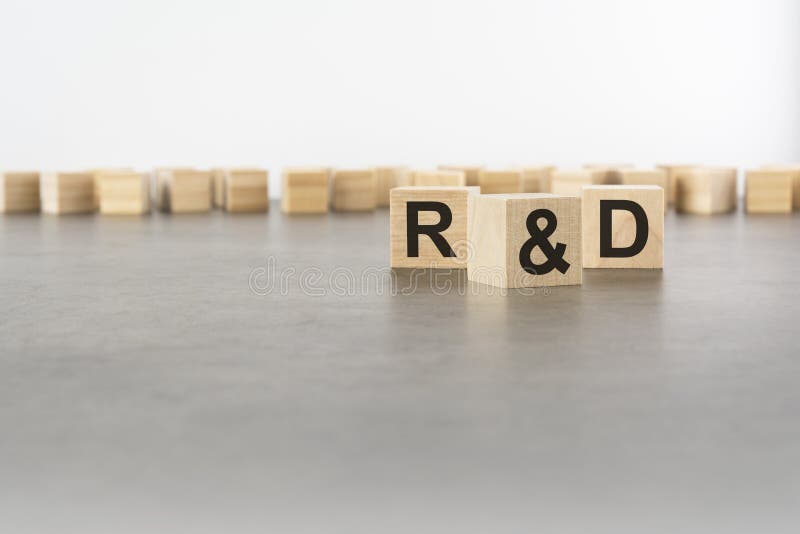 Three wooden blocks with letters R and D with focus to the single cube in the foreground in a conceptual image on grey royalty free stock image