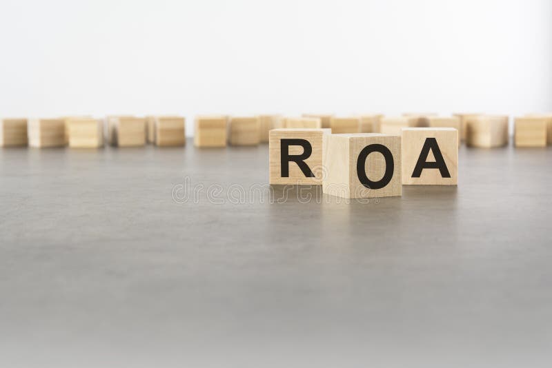 Three wooden blocks with letters ROA with focus to the single cube in the foreground in a conceptual image on grey royalty free stock photography