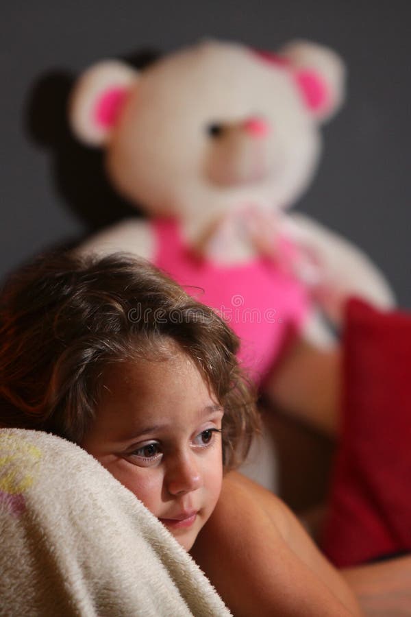 A three year old girl watches television with her teddy bear. Behind her, latin, daydreaming, park, woman, cheerful, happy, imagination, female, outdoors royalty free stock photo A three year old girl watches television with her teddy bear. Behind her, latin, daydreaming, park, woman, cheerful, happy, imagination, female, outdoors royalty free stock photo