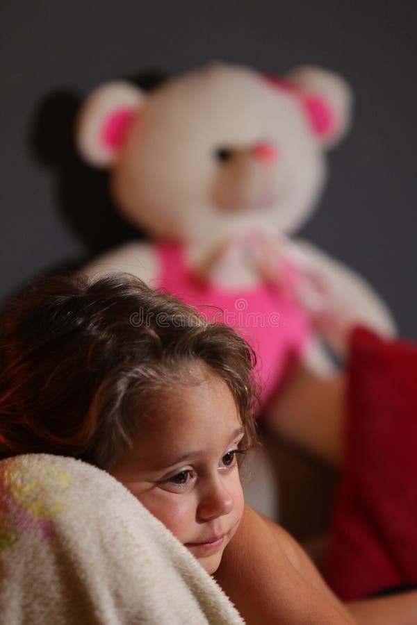 A three year old girl watches television with her teddy bear. Behind her, latin, daydreaming, park, woman, cheerful, happy, imagination, female, outdoors stock images A three year old girl watches television with her teddy bear. Behind her, latin, daydreaming, park, woman, cheerful, happy, imagination, female, outdoors stock images