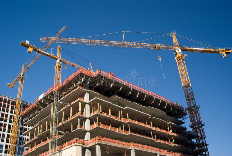 Three yellow cranes over construction site