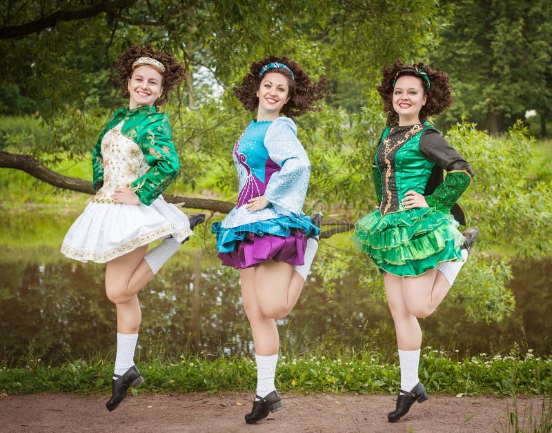 Three young beautiful girls in irish dance dress and wig dancing royalty fr...