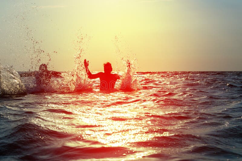 Three young men splashing water in the sea royalty free stock images Three young men splashing water in the sea royalty free stock images