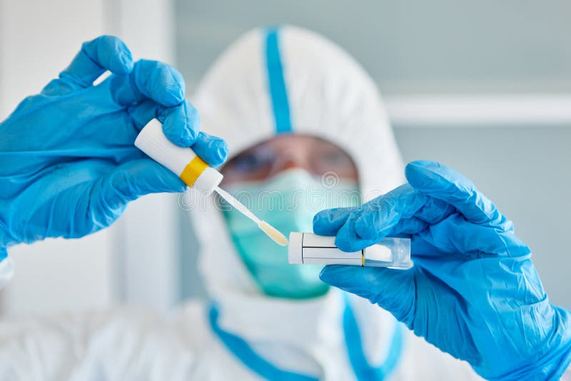 Medic in protective clothing with throat swab during saliva sample for coronavirus test. Medic in protective clothing with throat swab during saliva sample for coronavirus test