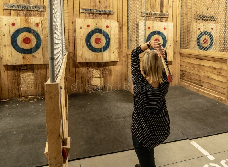 A woman prepares to throw an axe at a target at an Axe throwing facility in Louisville, KY. A woman prepares to throw an axe at a target at an Axe throwing facility in Louisville, KY.