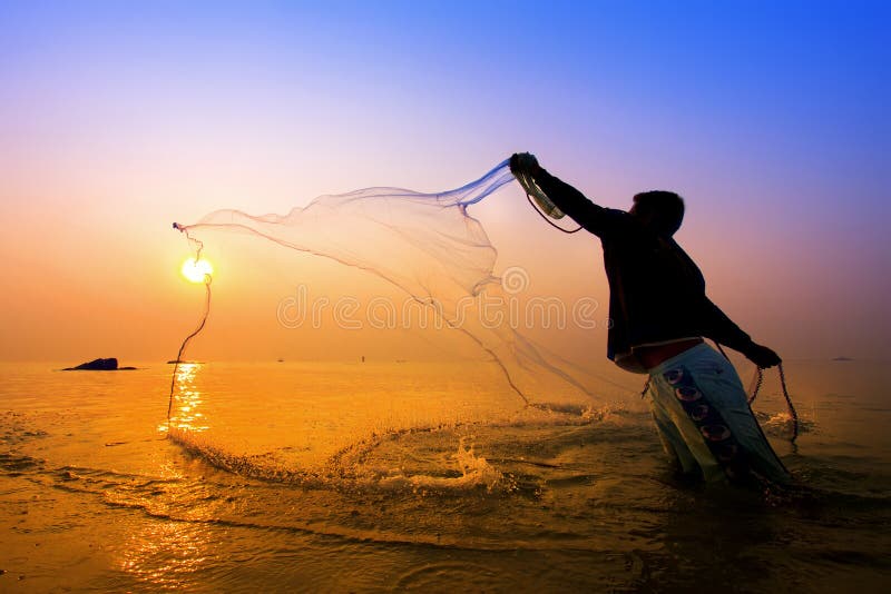 Throwing fishing net during sunrise
