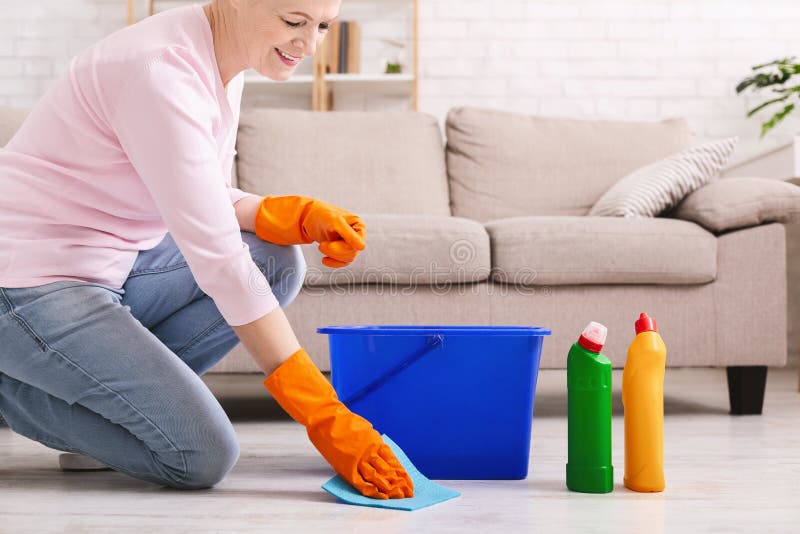 Thuis glimlachend rijpe huisvrouwen schoonmakende vloer stock afbeelding Thuis glimlachend rijpe huisvrouwen schoonmakende vloer stock afbeelding