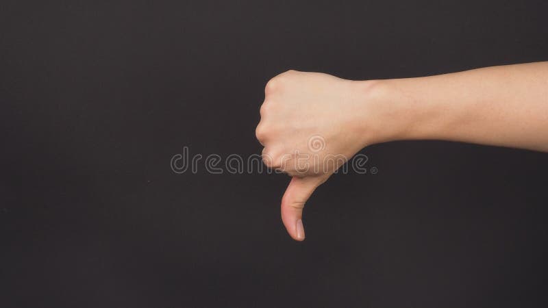 The thumbs down hand sign on black background. it use when you don`t like or approve of something