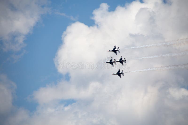 The underside of four USAF Thunderbirds against a cloudy sky, trailing smoke. The underside of four USAF Thunderbirds against a cloudy sky, trailing smoke.