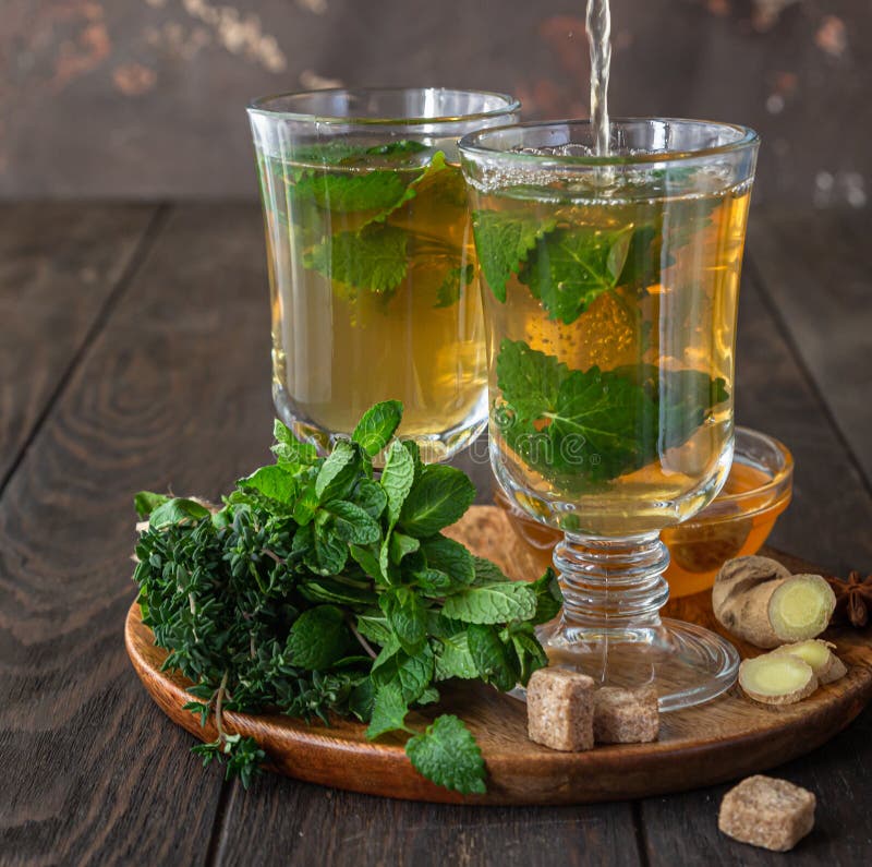 Thé de brassage. thé chaud aux herbes ou à la menthe avec du gingembre aux herbes fraîches et du fond en bois de miel image stock