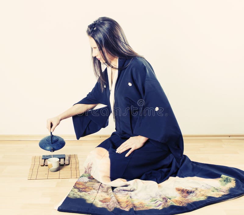 Thé se renversant de port de kimono de jeune femme photos stock Thé se renversant de port de kimono de jeune femme photos stock