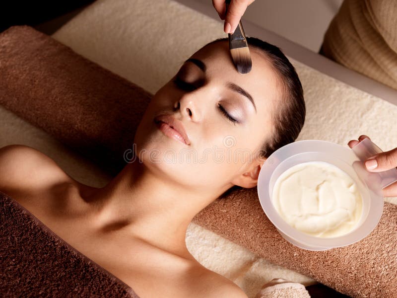 Thérapie de station thermale pour la femme recevant le masque facial photo libre de droits Thérapie de station thermale pour la femme recevant le masque facial photo libre de droits