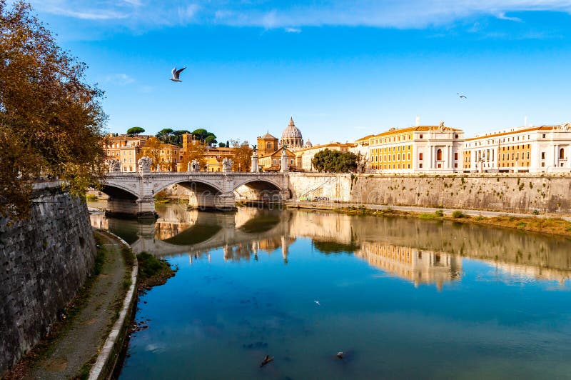 Tiber-Flussströme, Brücke Ponte Vittorio Emanuele II, fliegende Seemöwen und Rom-Stadtbildansicht mit St- Peterhaube auf stockfotografie Tiber-Flussströme, Brücke Ponte Vittorio Emanuele II, fliegende Seemöwen und Rom-Stadtbildansicht mit St- Peterhaube auf stockfotografie