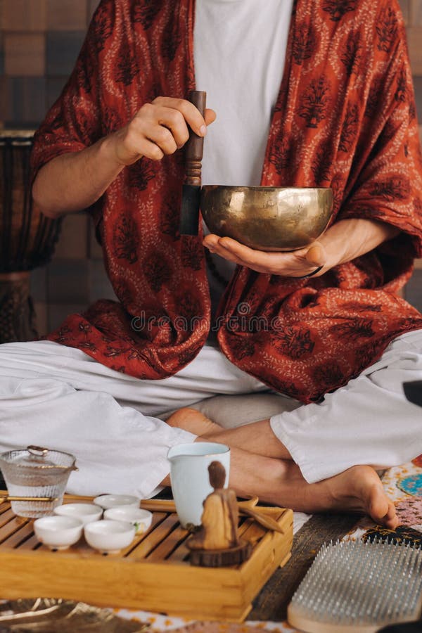 Tibetan Singing Bowl in the Hands of a Man during a Tea Ceremony Stock