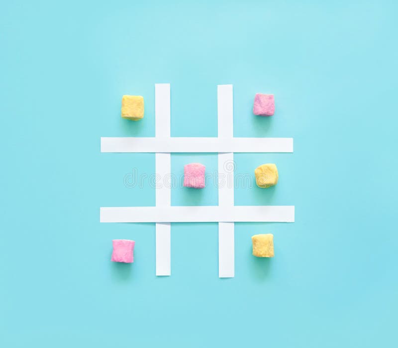 Tic tac toe παιχνίδι ή xo παιχνίδι από πολύχρωμα ζαχαρωτά. δακτύλιος διαβάθμισης από ροζ και κίτρινα ζαχαρωτά σε μπλε φόντο