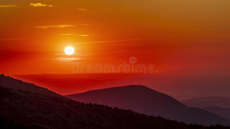 Tidslinje vid solnedgång en detaljerad solvy då den ändras från gult till rött och långsamt sätter sig bakom bergsregionen