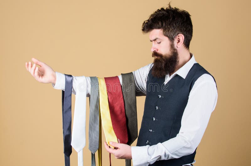 Tie the perfect for daily wear. Bearded man choosing neck tie. Brutal hipster holding colorful tie collection. Offering a huge selection of ties.