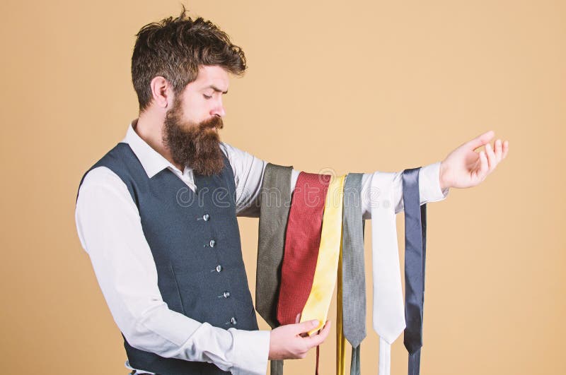 Tie the perfect for daily wear. Bearded man choosing neck tie. Brutal hipster holding colorful tie collection. Offering a huge selection of ties.