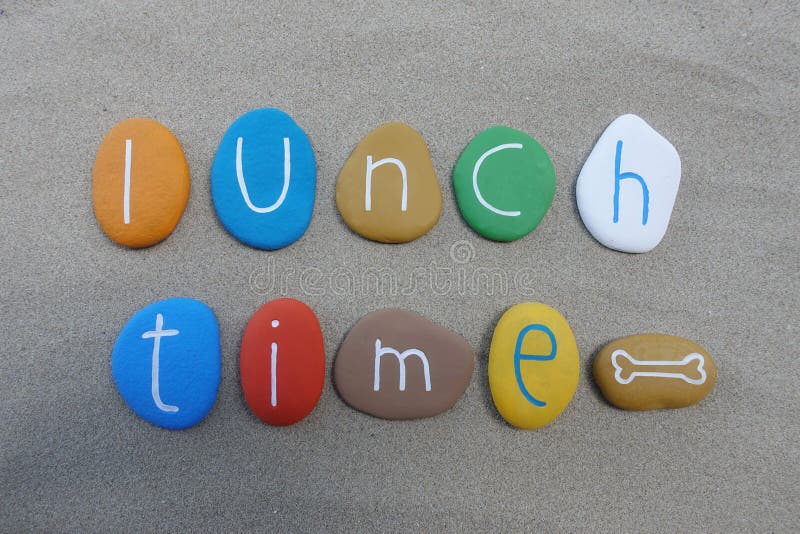 Tiempo del almuerzo, composición multicolora conceptual de las piedras sobre la arena de la playa foto de archivo libre de regalías Tiempo del almuerzo, composición multicolora conceptual de las piedras sobre la arena de la playa foto de archivo libre de regalías