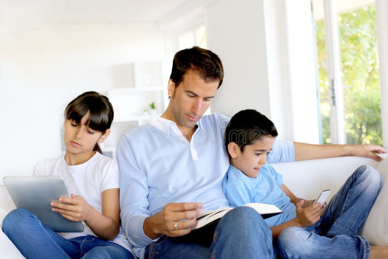 Tiempo spedning de la familia junto pero por separado fotografía de archivo Tiempo spedning de la familia junto pero por separado fotografía de archivo