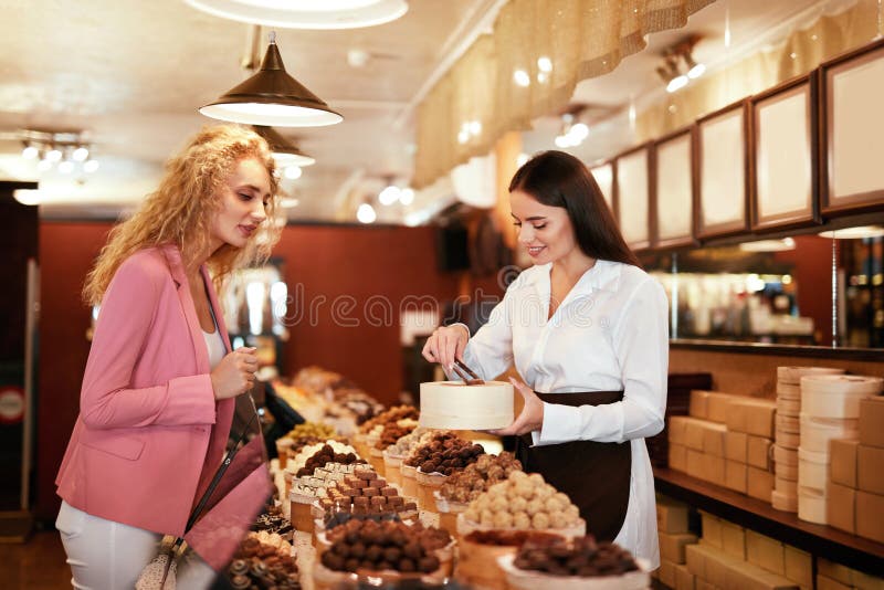 Tienda del chocolate Dulces de compra del chocolate de la mujer en tienda imagen de archivo libre de regalías Tienda del chocolate Dulces de compra del chocolate de la mujer en tienda imagen de archivo libre de regalías