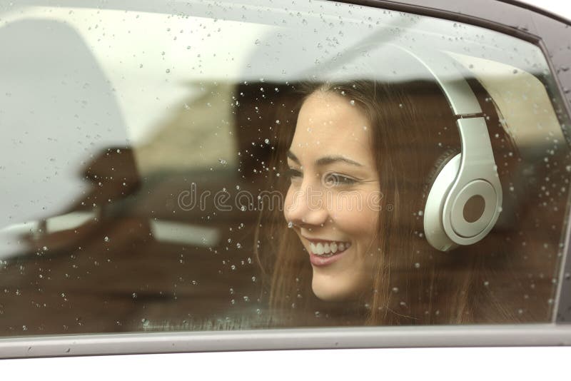 Happy teenager with headphones listening to the music inside a car and looking away. Happy teenager with headphones listening to the music inside a car and looking away