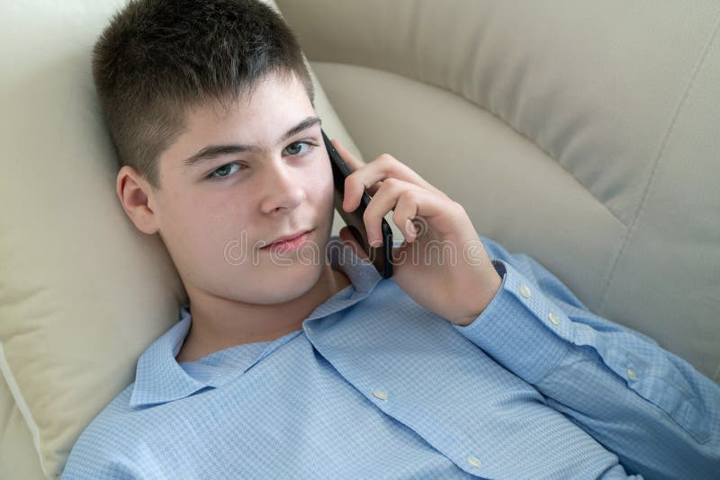 Tiener die op Celtelefoon spreken die op Bank liggen royalty-vrije stock fotografie Tiener die op Celtelefoon spreken die op Bank liggen royalty-vrije stock fotografie
