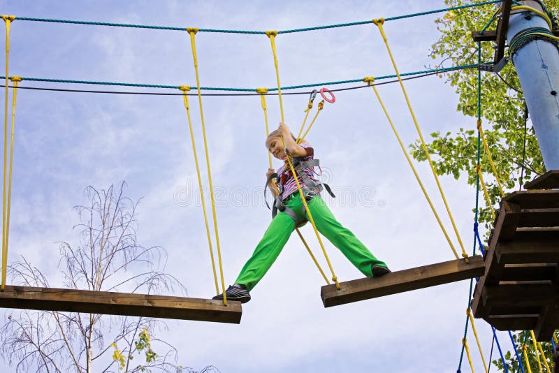 Tiener meisje loopt op een plank in een touwenpark royalty-vrije stock afbeelding