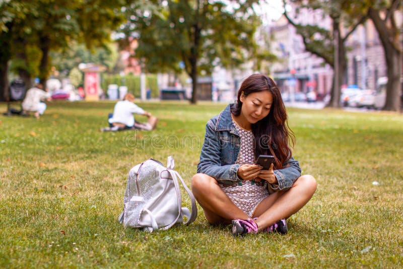 Tiener die in Park legt dat Mobiele Telefoon met behulp van royalty-vrije stock foto Tiener die in Park legt dat Mobiele Telefoon met behulp van royalty-vrije stock foto