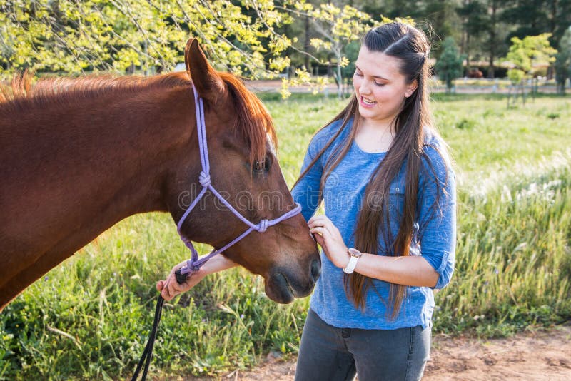 Tiener die zich in openlucht met haar kastanje Arabisch paard bevinden stock foto's Tiener die zich in openlucht met haar kastanje Arabisch paard bevinden stock foto's