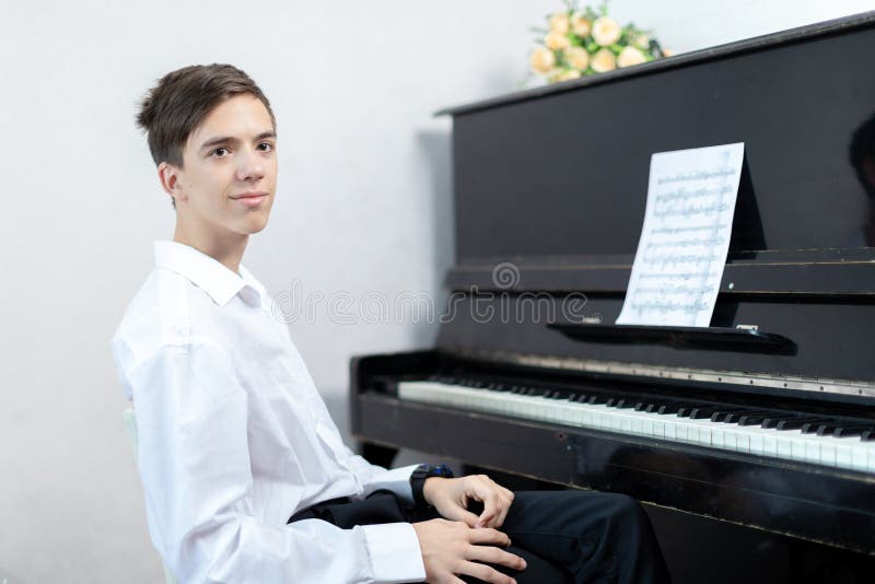 Teenage boys play piano in class or at home . student learn to play the piano. Teenage boys play piano in class or at home . student learn to play the piano