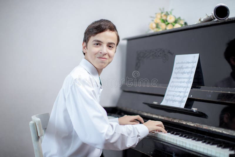 Teenage boys play piano in class or at home . student learn to play the piano. Teenage boys play piano in class or at home . student learn to play the piano